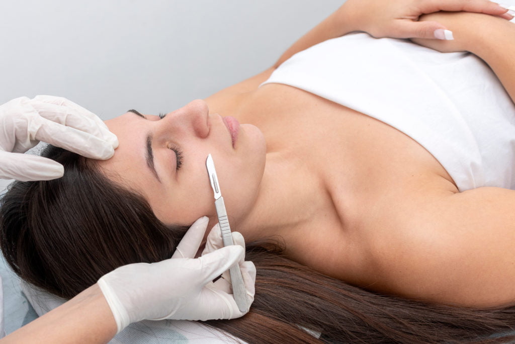 A Woman taking treatment on her face | Dermaplaning Cultivated Beauty Aesthetic in Guntersville, AL